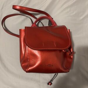 like new AUTHENTIC COACH small red backpack. iphone 15 phone case for size.